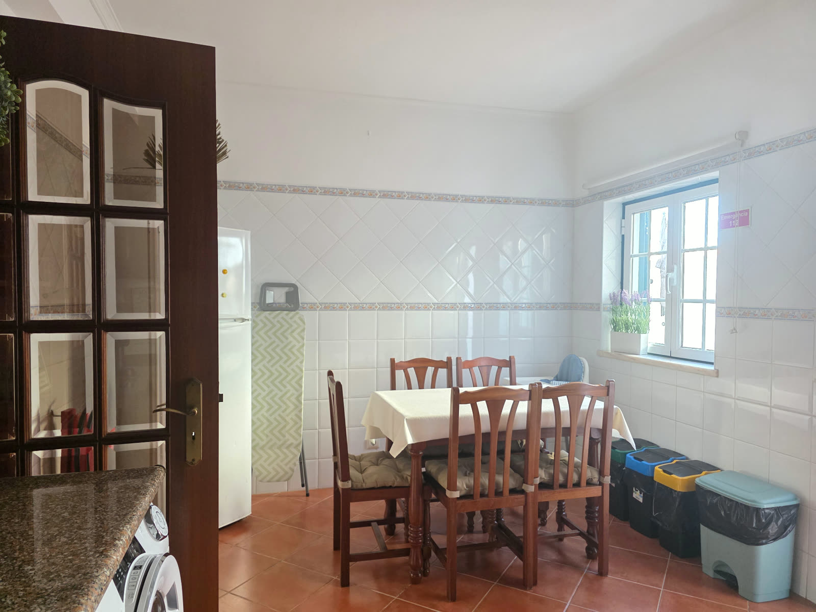Cozinha da Breeze House Almograve com mesa de refeições junto à janela