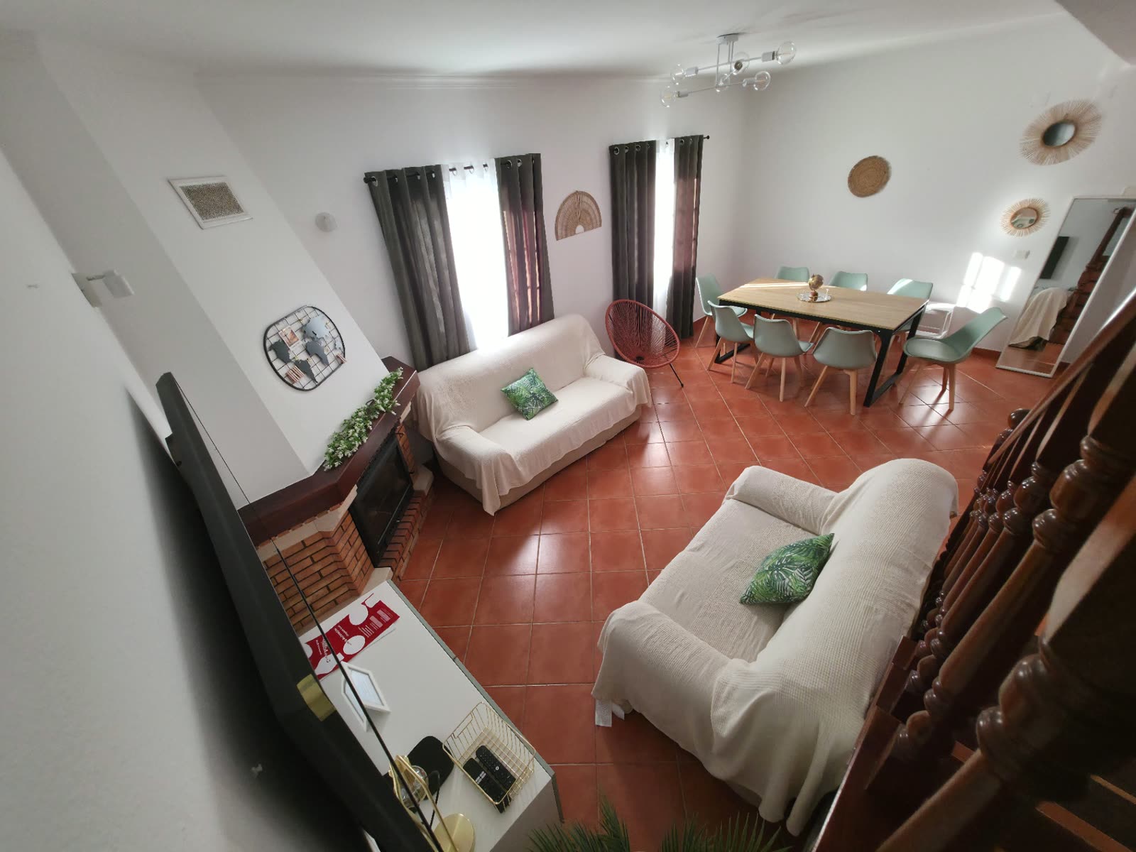 Sala de estar e zona de refeições da Breeze House Almograve, com lareira e mesa para seis pessoas
