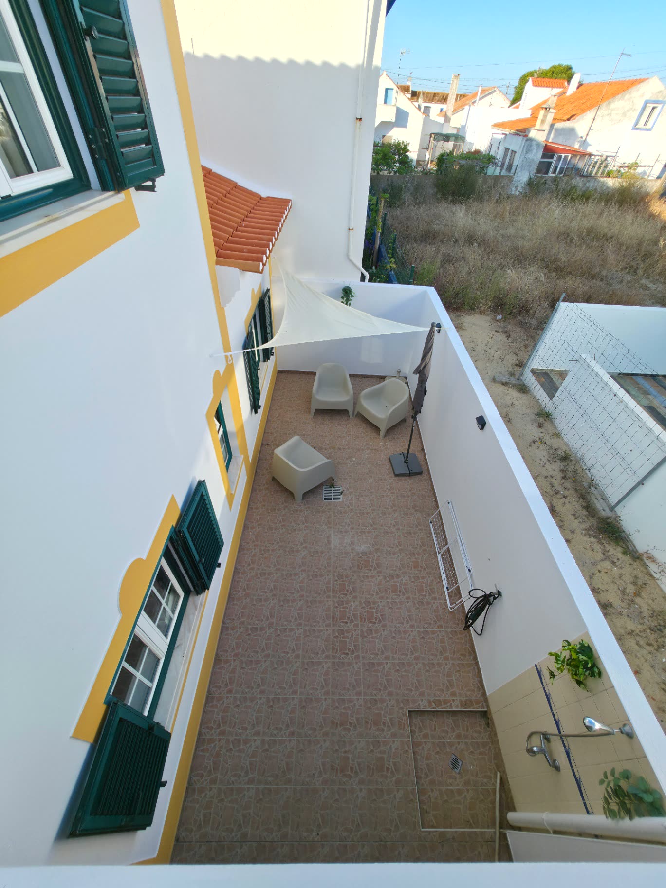 Vista de cima do terraço da Breeze House Almograve com vela de sombra e duche exterior